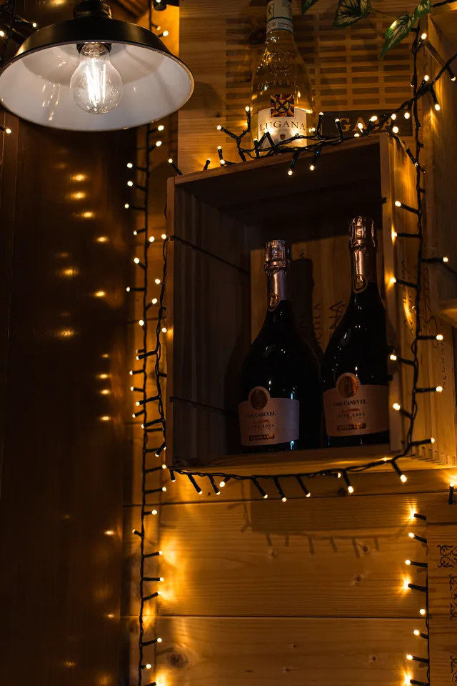 Una nicchia di bottiglie illuminata da piccole luci nella sala della Locanda degli Scaligeri