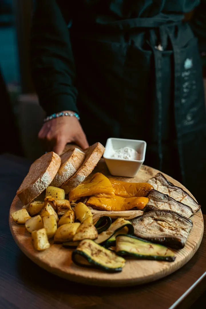 Un tagliere con pane, patate al forno e verdure grigliate servito in tavola – Locanda degli Scaligeri, Verona